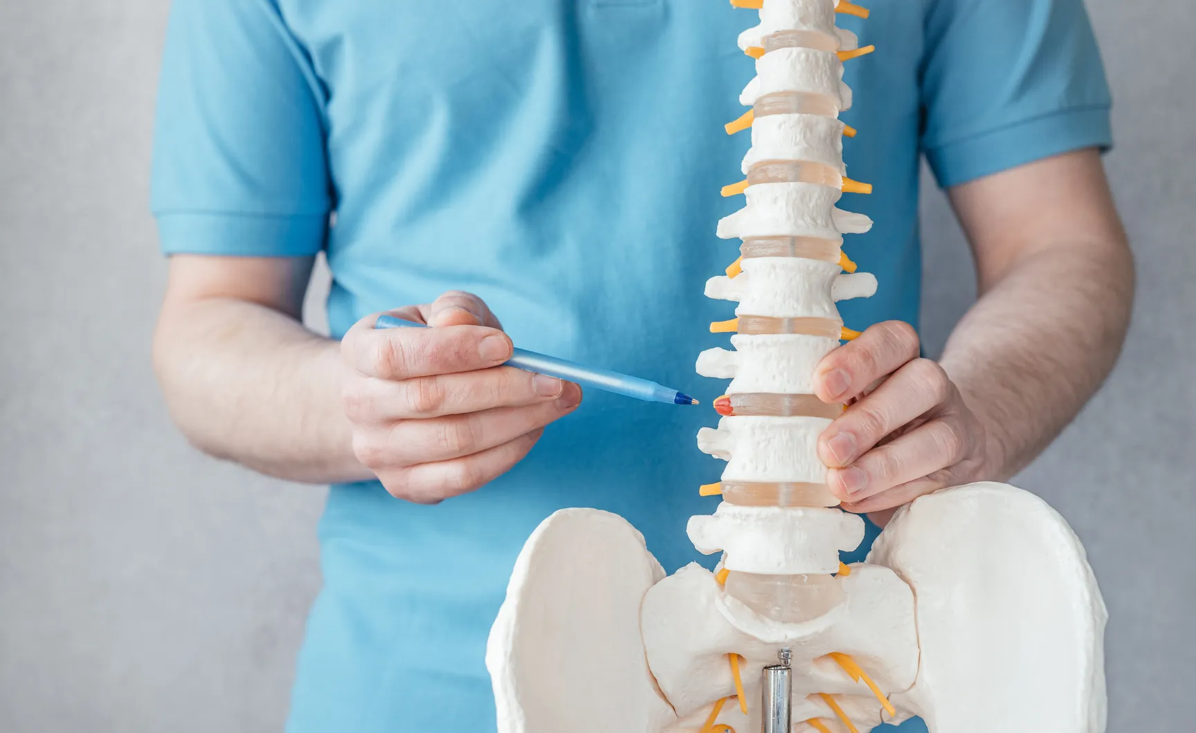 Diagram of a spinal disc bulging outwards and pressing on a nerve