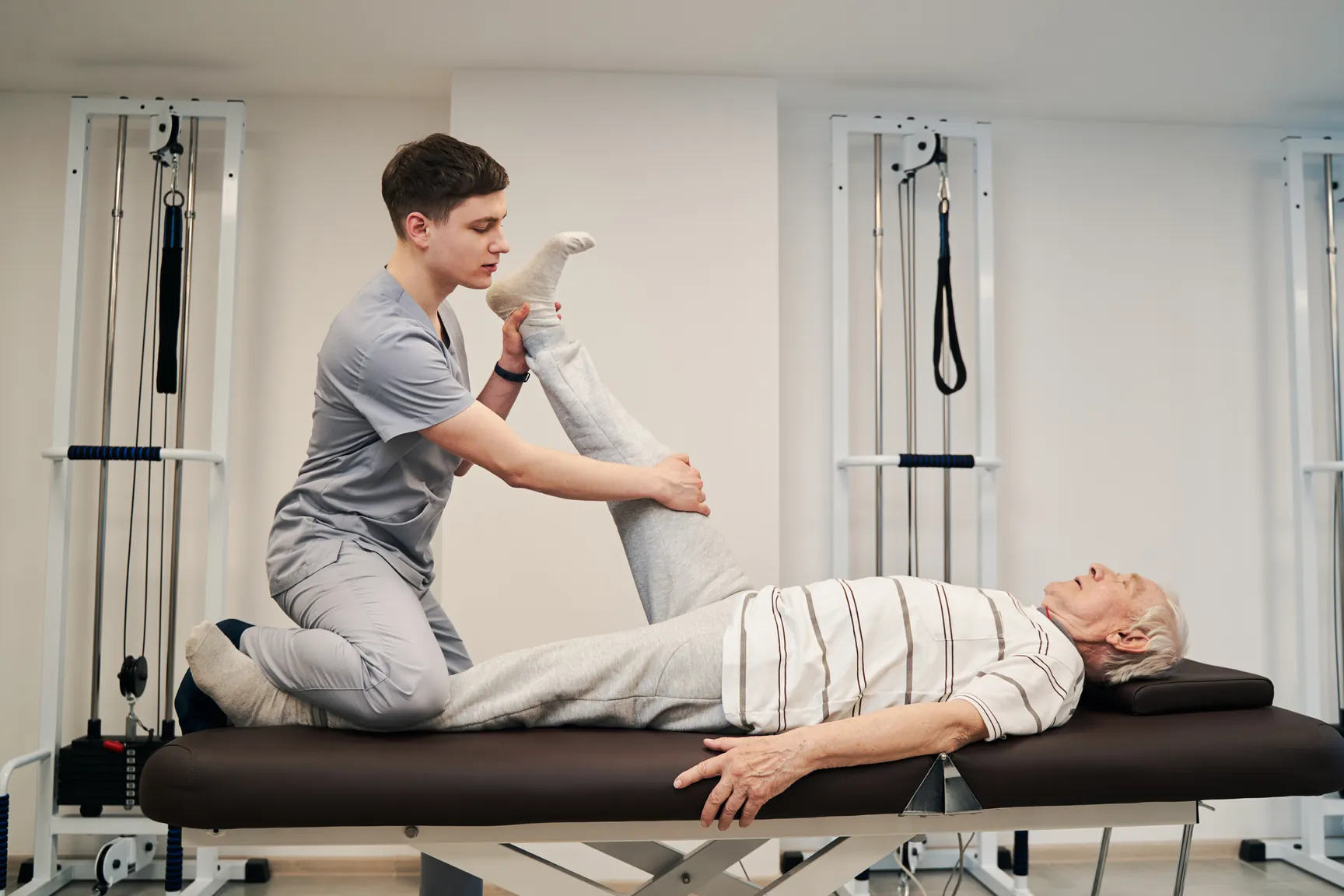 Physiotherapist helping a patient ease sciatica leg pain