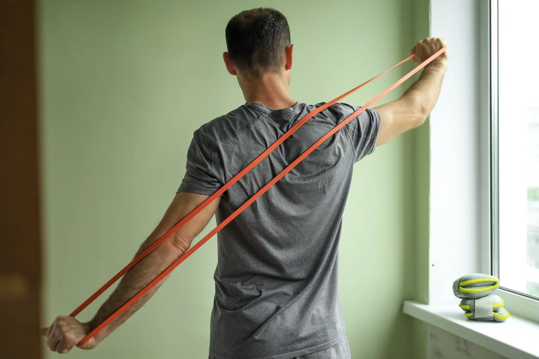 Physiotherapist guiding a patient through a shoulder strengthening exercise