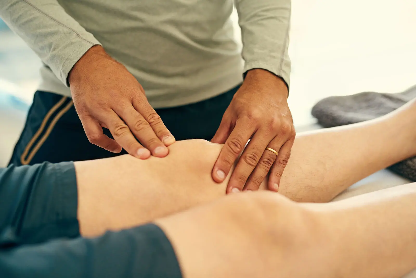 Physiotherapist examining a patient's knee